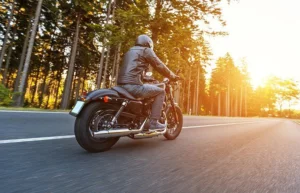 A motorcycle rider driving down a California road